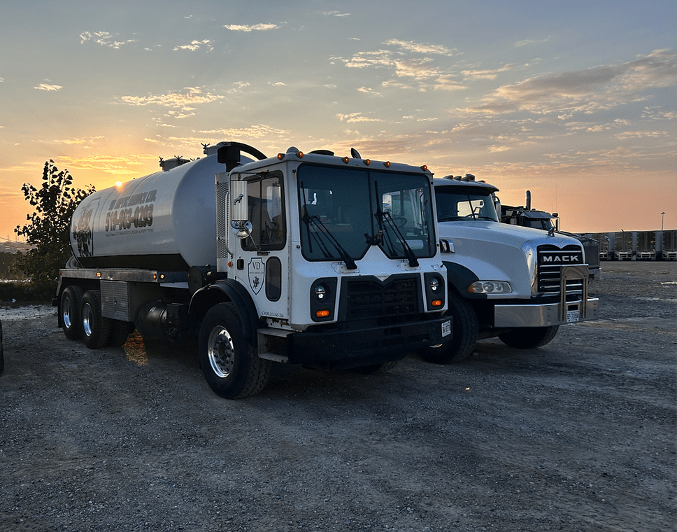 VDN Septic Service Ltd trucks at dusk